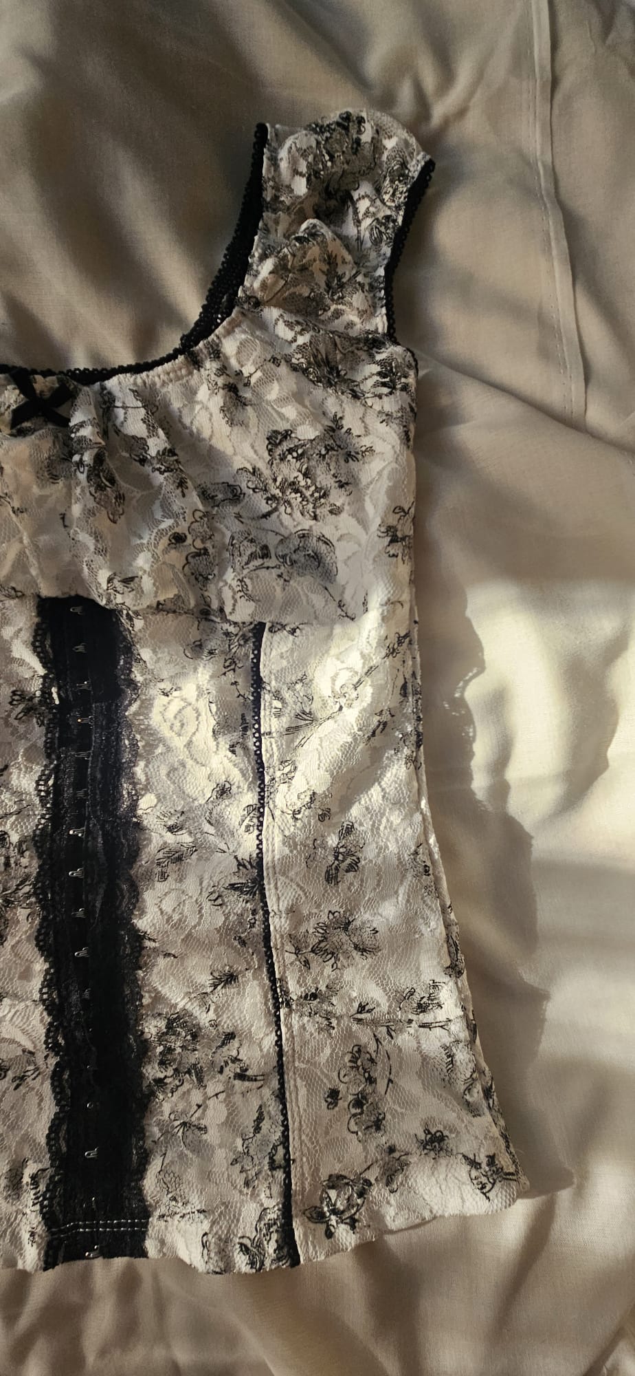 Floral top with black lace details on a beige surface