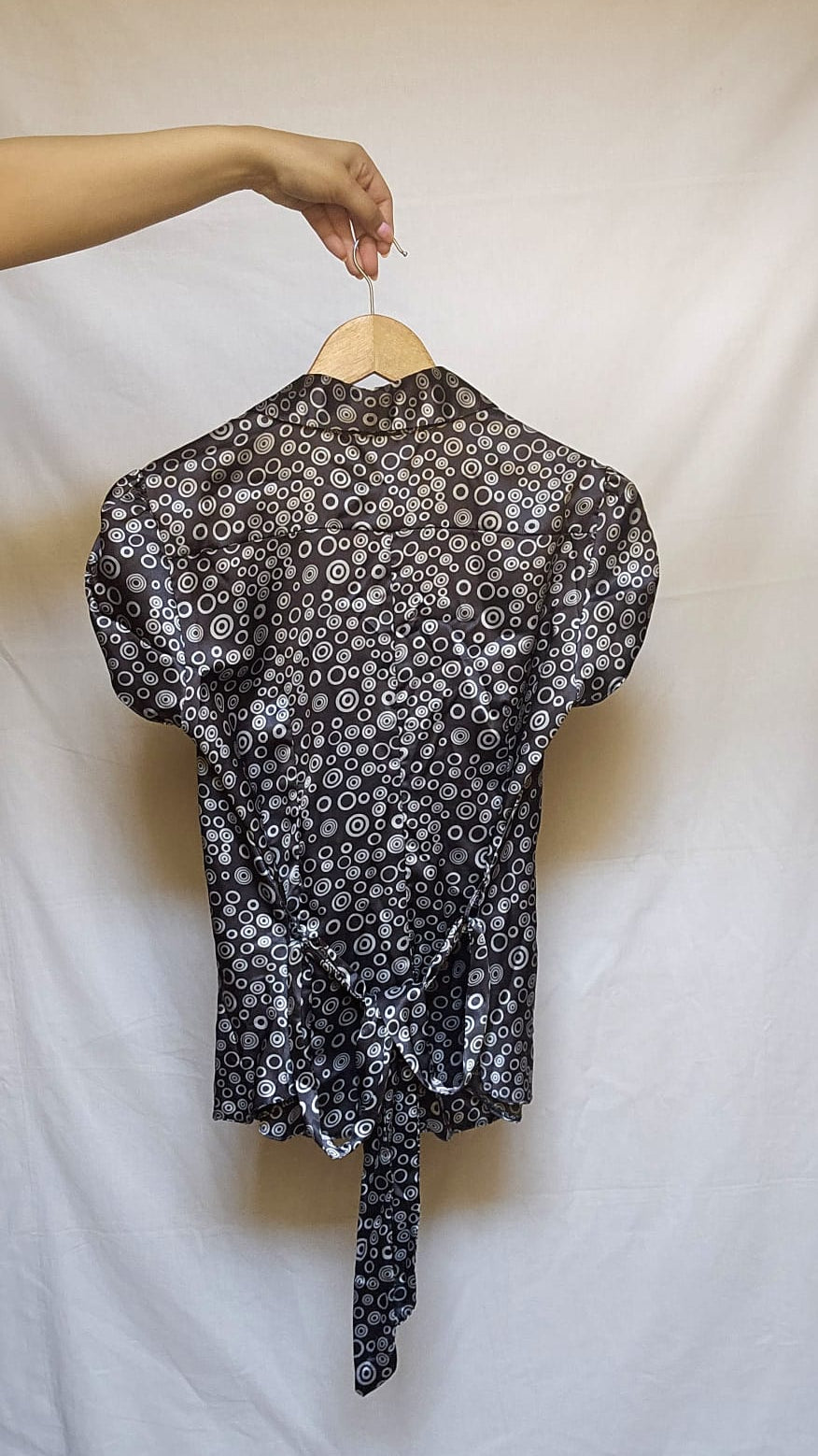 Black and white patterned top on a hanger against a white background