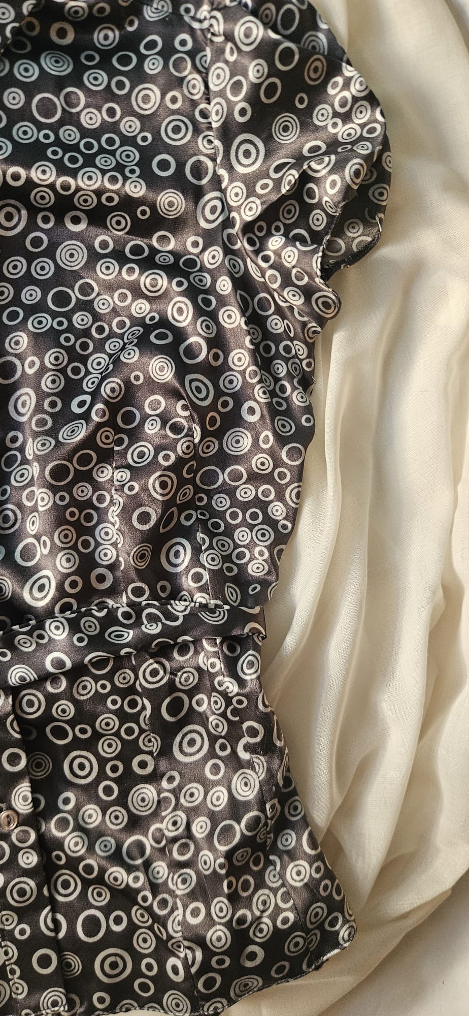 Patterned top with circular designs on a plain background