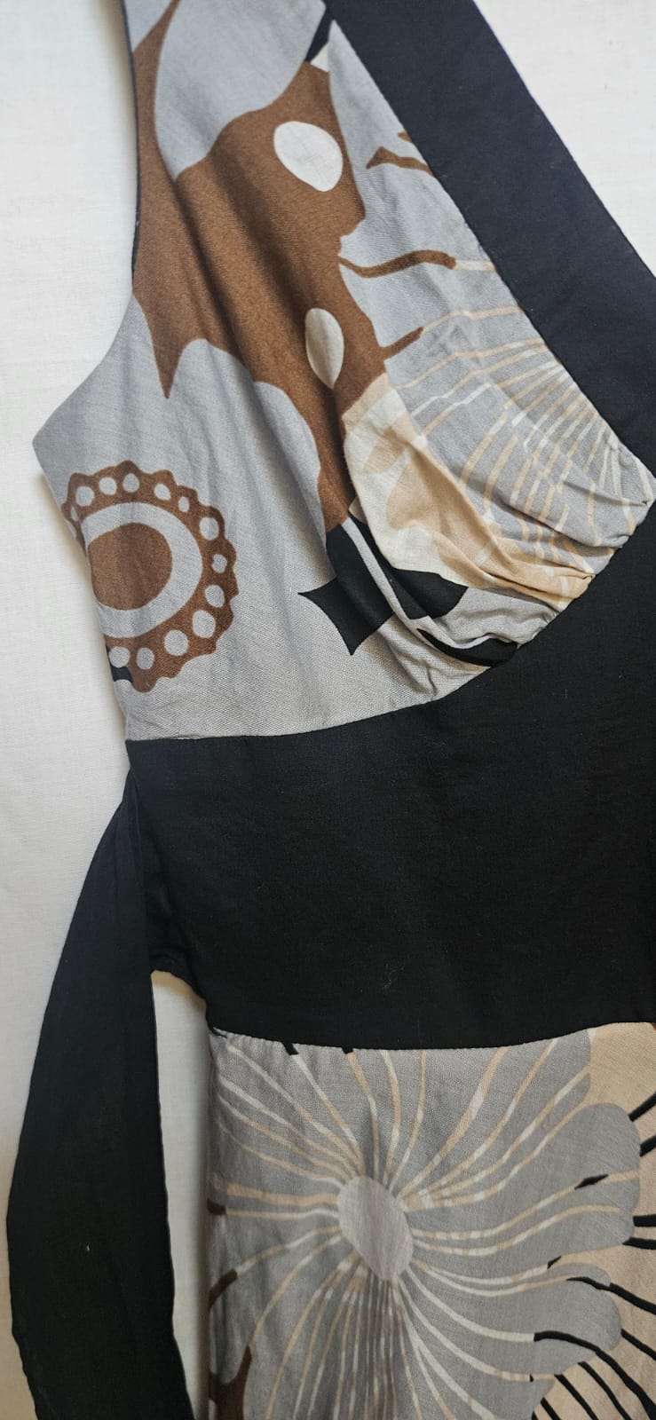 Dress with abstract patterns in brown, beige, and black on a white background