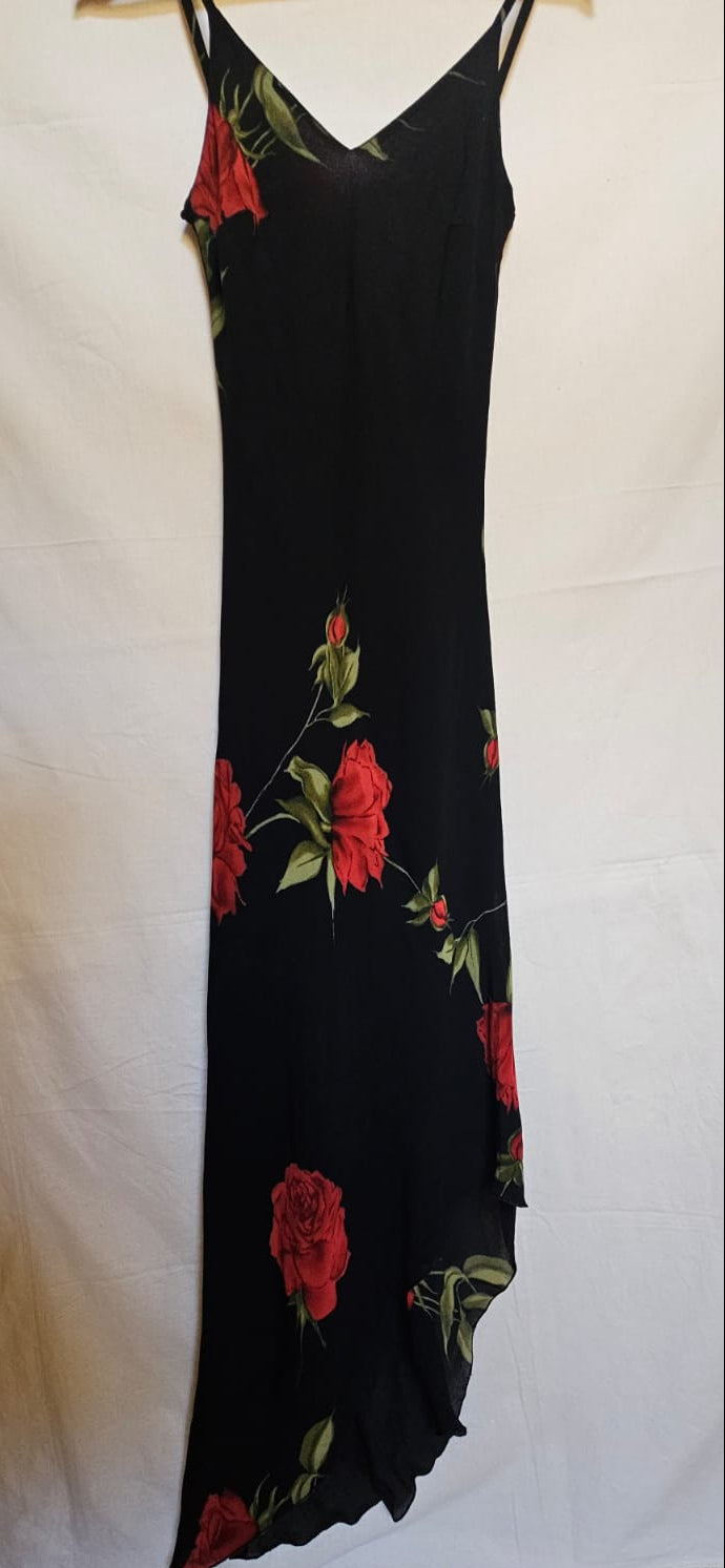 Black slip dress with red floral pattern on a white background