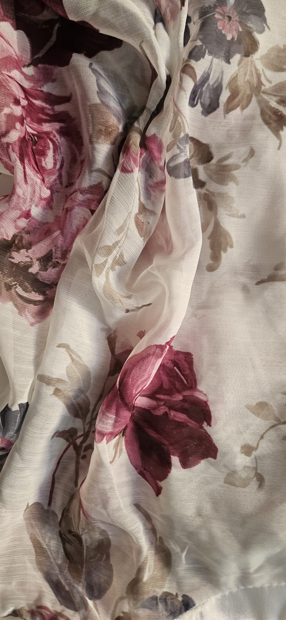 Close-up of floral blouse with pink and red flowers on a white background