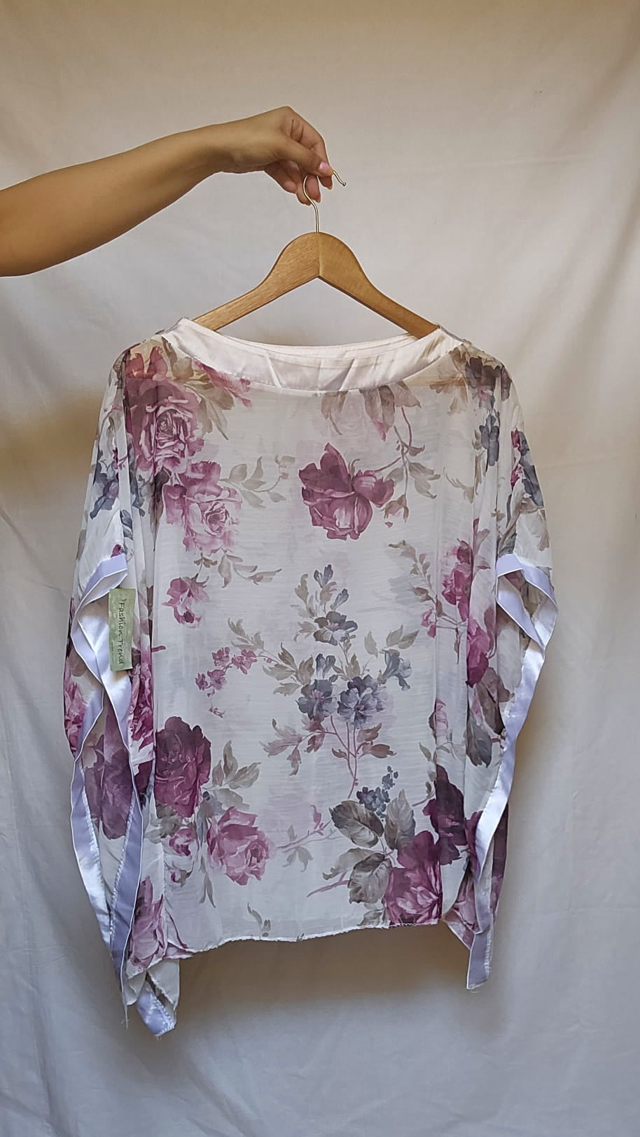 Floral-patterned garment on a hanger against a plain background