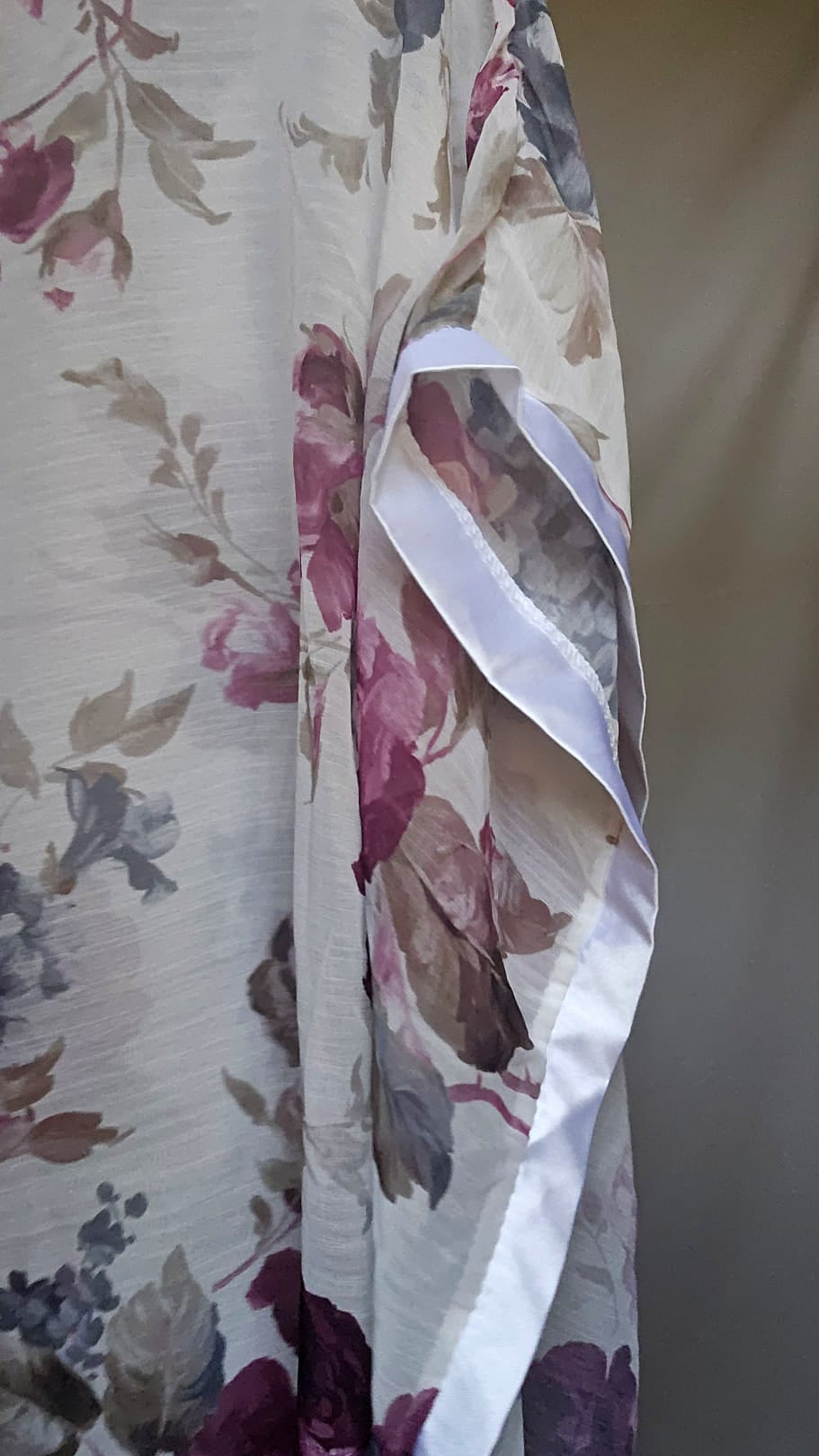 Floral patterned blouse with a white border on a plain background