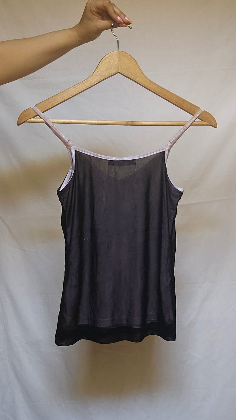 Black tank top on a hanger against a white background