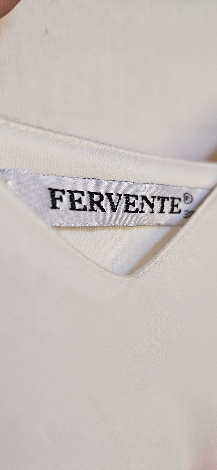 Close-up of a 'Fervente' brand label on a garment.