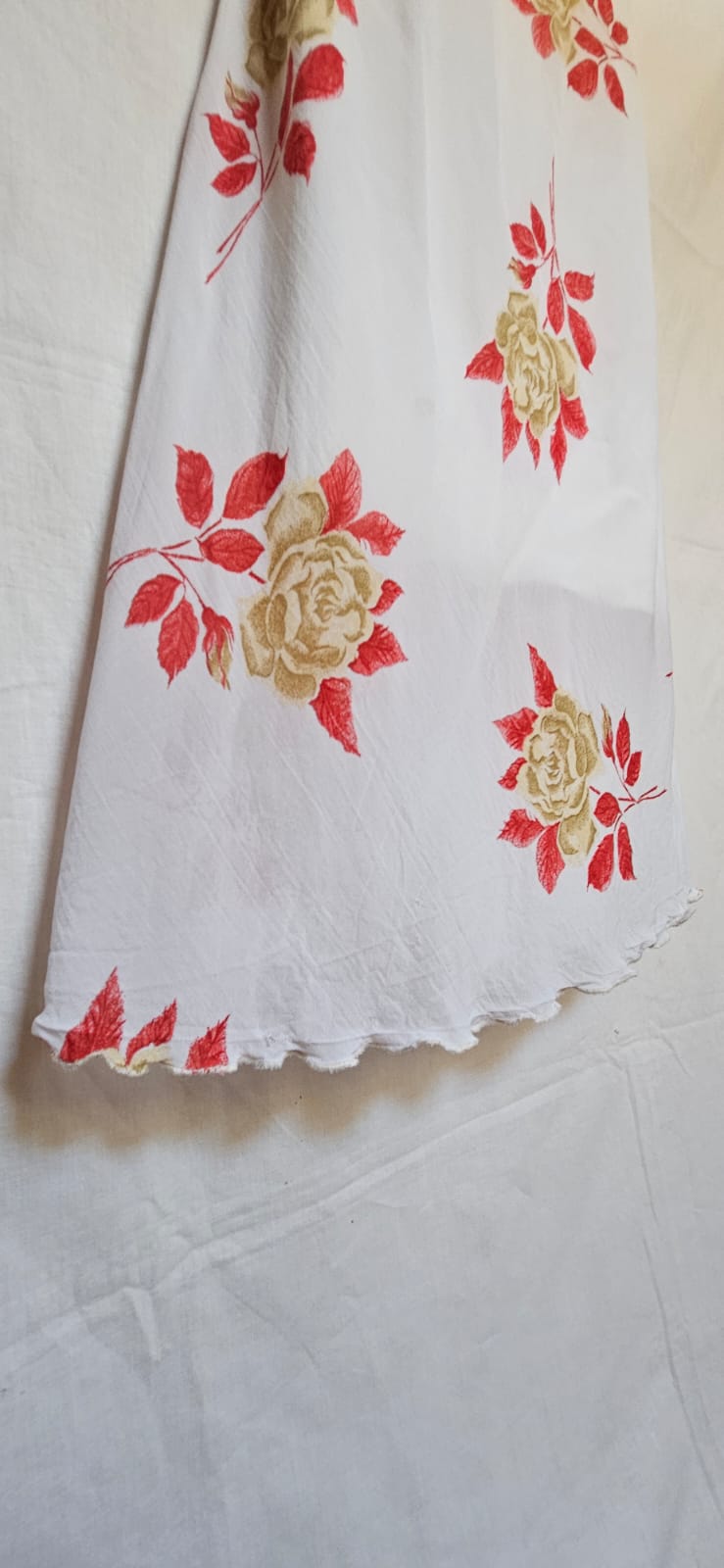 Floral patterned dress with red and gold roses on a white background