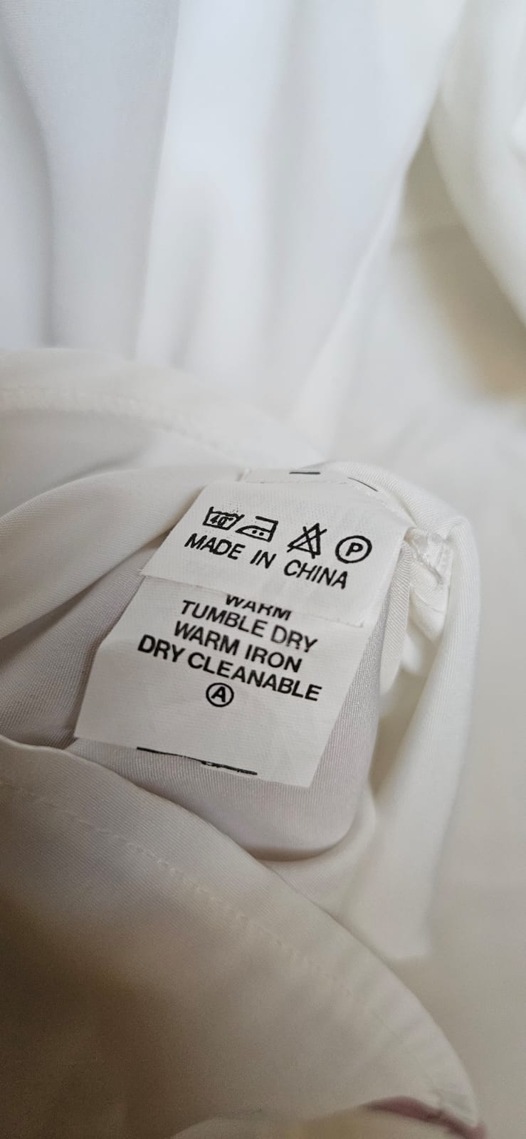 Care label - Made in China, warm wash, tumble dry, warm iron, dry cleanable