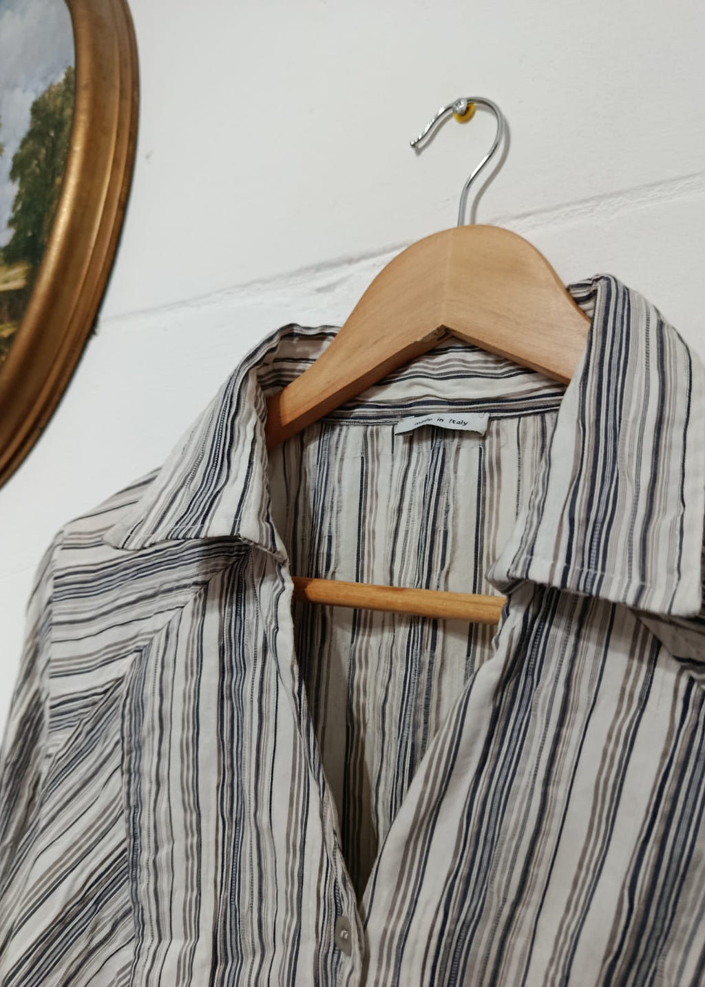 Close-up of a neutral striped button-down shirt made with 60% cotton